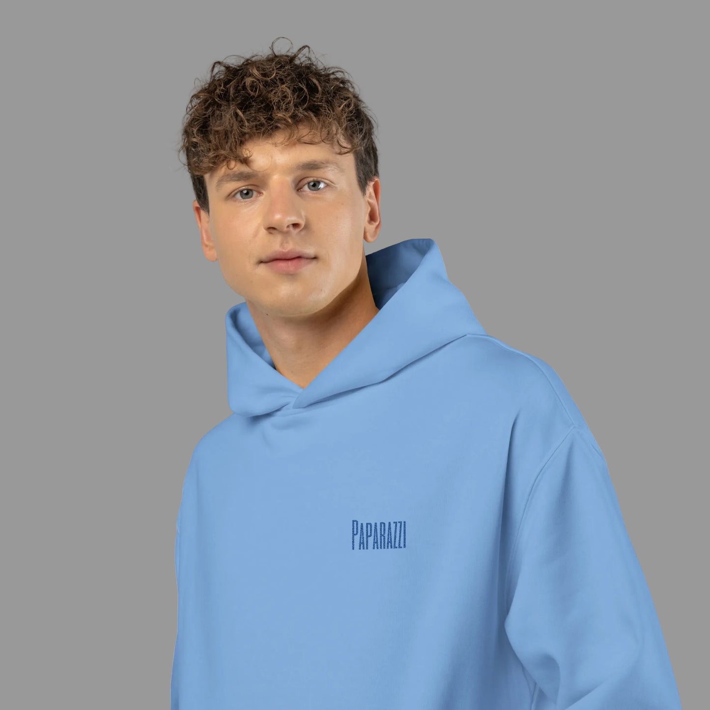 Guy wearing a light blue hoodie with a Paparazzi logo on left chest