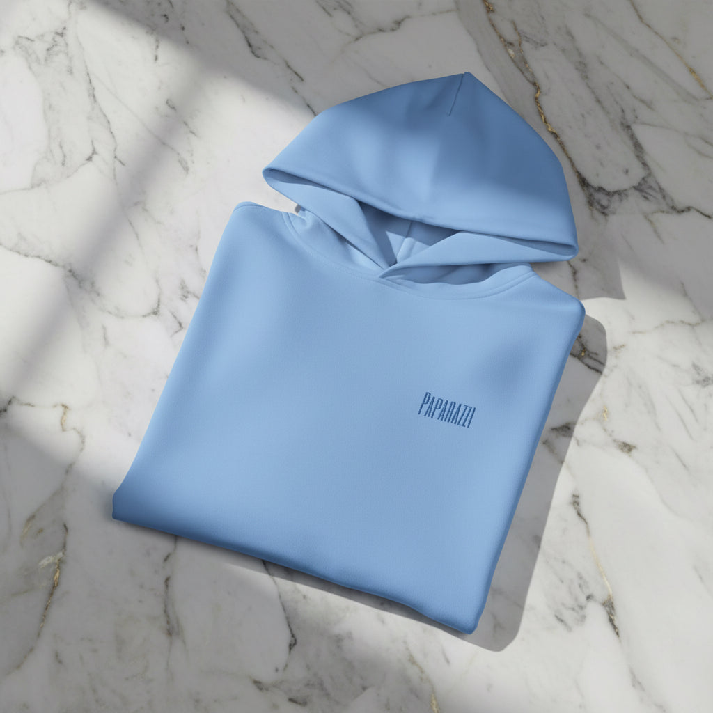 Folded blue hoodie with a logo on a white background