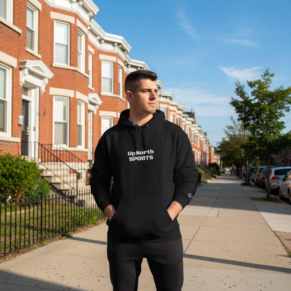 Man wearing a black hoodie with a UpNorth Sports design logo, standing outside.